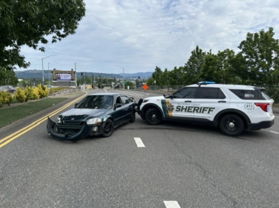 Side profile scene showing a white and green Multnomah County Sheriff’s Office patrol SUV...