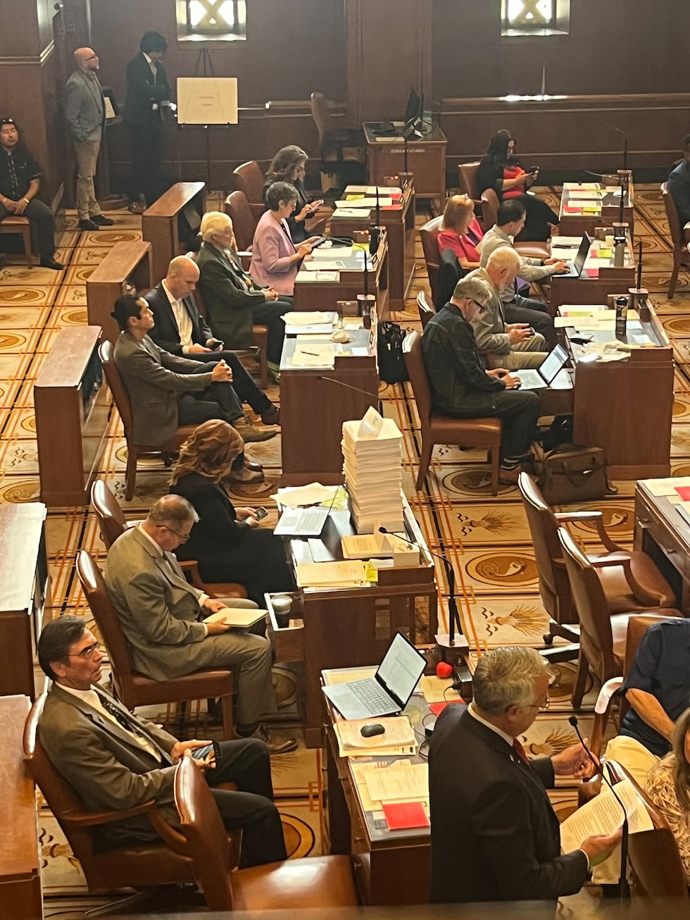 Public testimony papers labeled “OPPOSITION” on Rep. Drazan’s desk.
