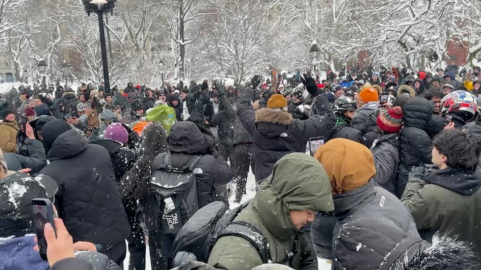 In this photo taken from video, people throw and duck snowballs during a snowball fight at...