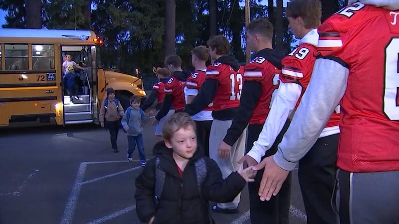 Oregon City football team greeting elementary school students