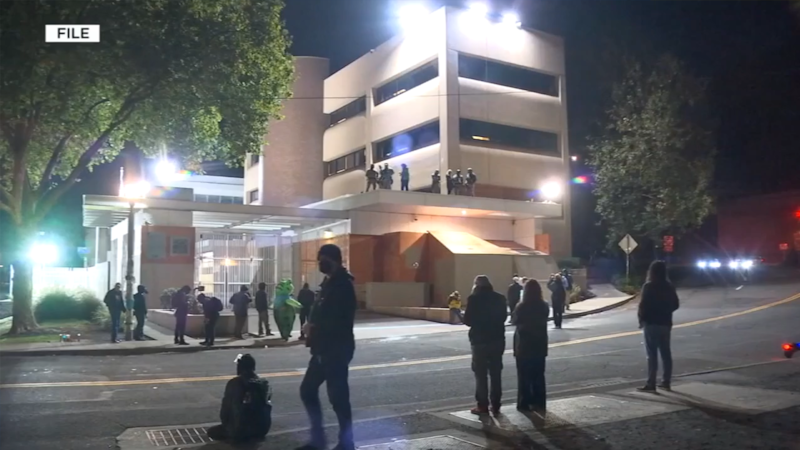FILE - A small group of protesters stands outside the Portland, Ore., ICE facility in 2025.