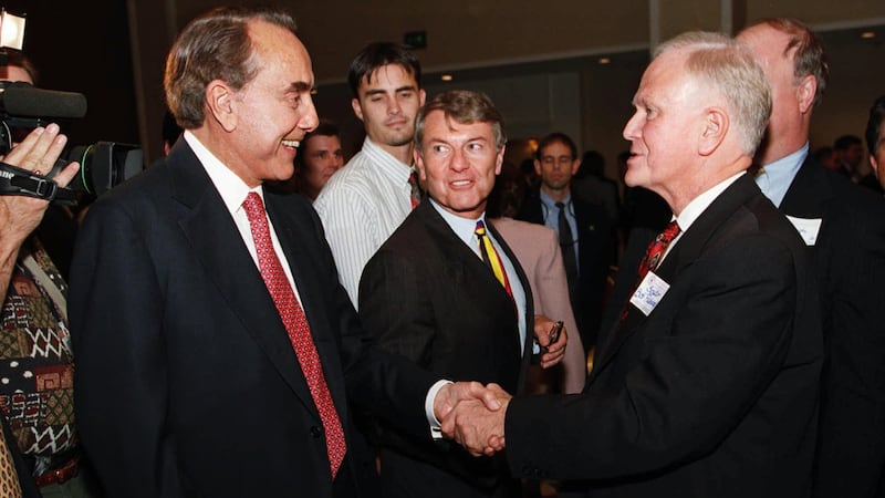 Former presidential candidate Bob Dole shakes hands with former U.S. Senator Bob Packwood,...
