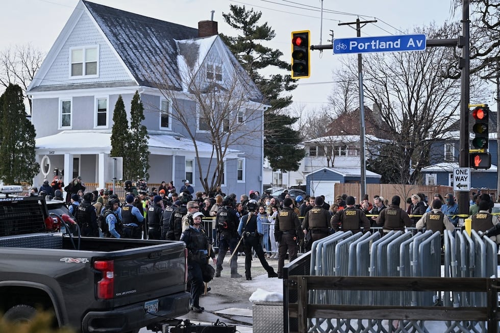 People protest as law enforcement officers attend to the scene of the shooting involving...